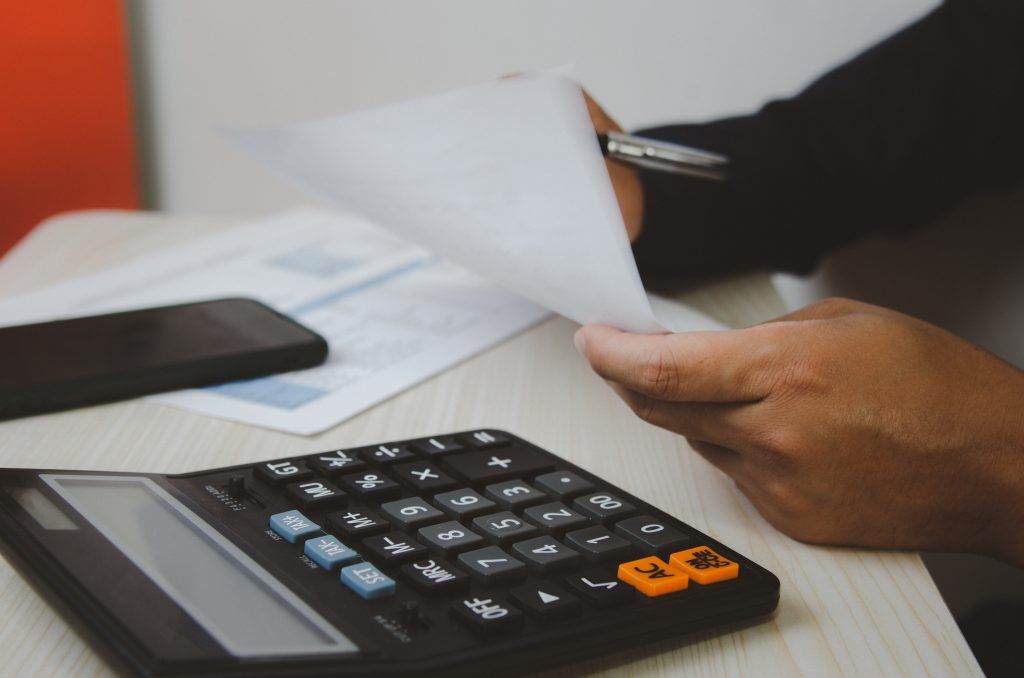 Calculator and documents representing cost considerations for Medicaid rehab centers.
