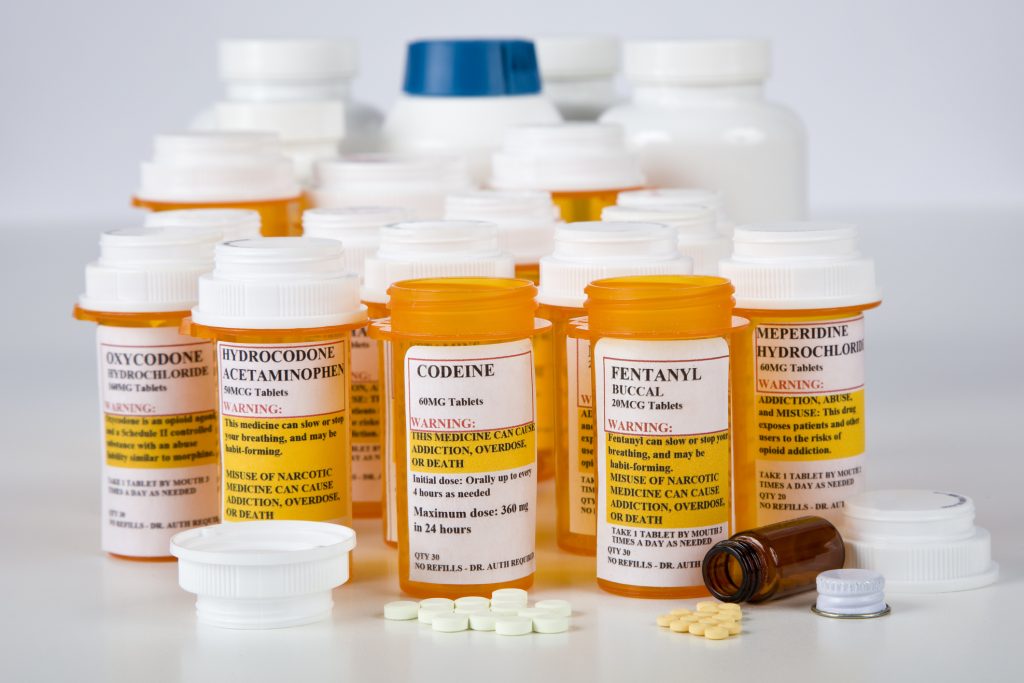 Conceptual image representing addiction to painkillers, highlighting prescription bottles and an individual in distress