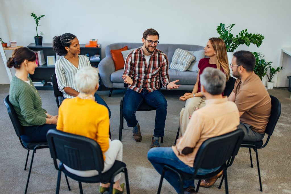 Support group members engaging in discussion for substance abuse recovery