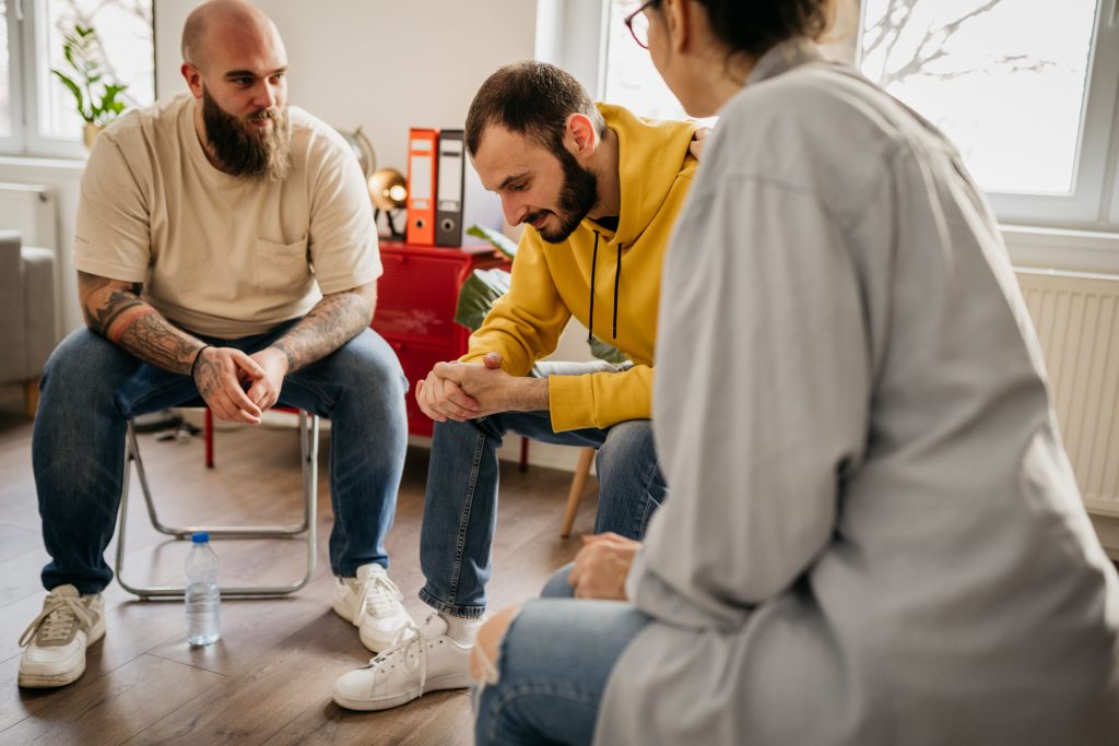 A group of individuals engaged in a supportive discussion during a Narcotics Anonymous meeting