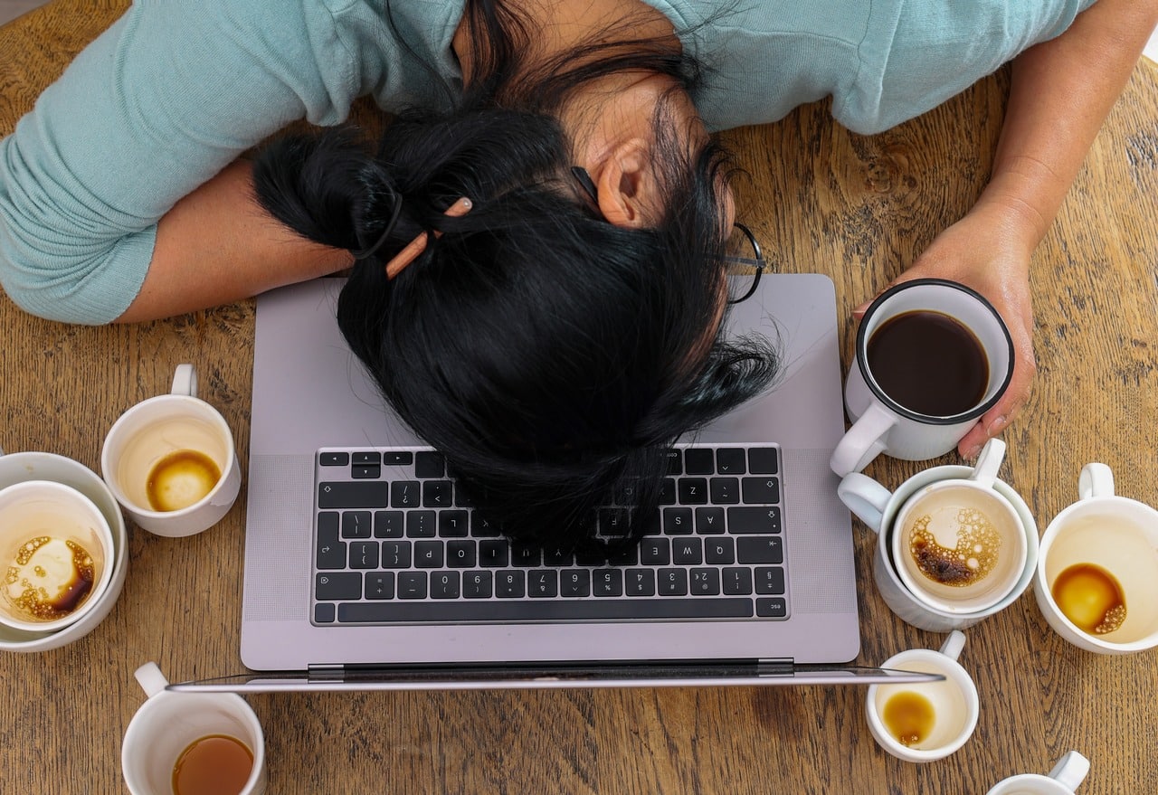 A steaming cup of coffee on a wooden table, highlighting caffeine's addictive properties.