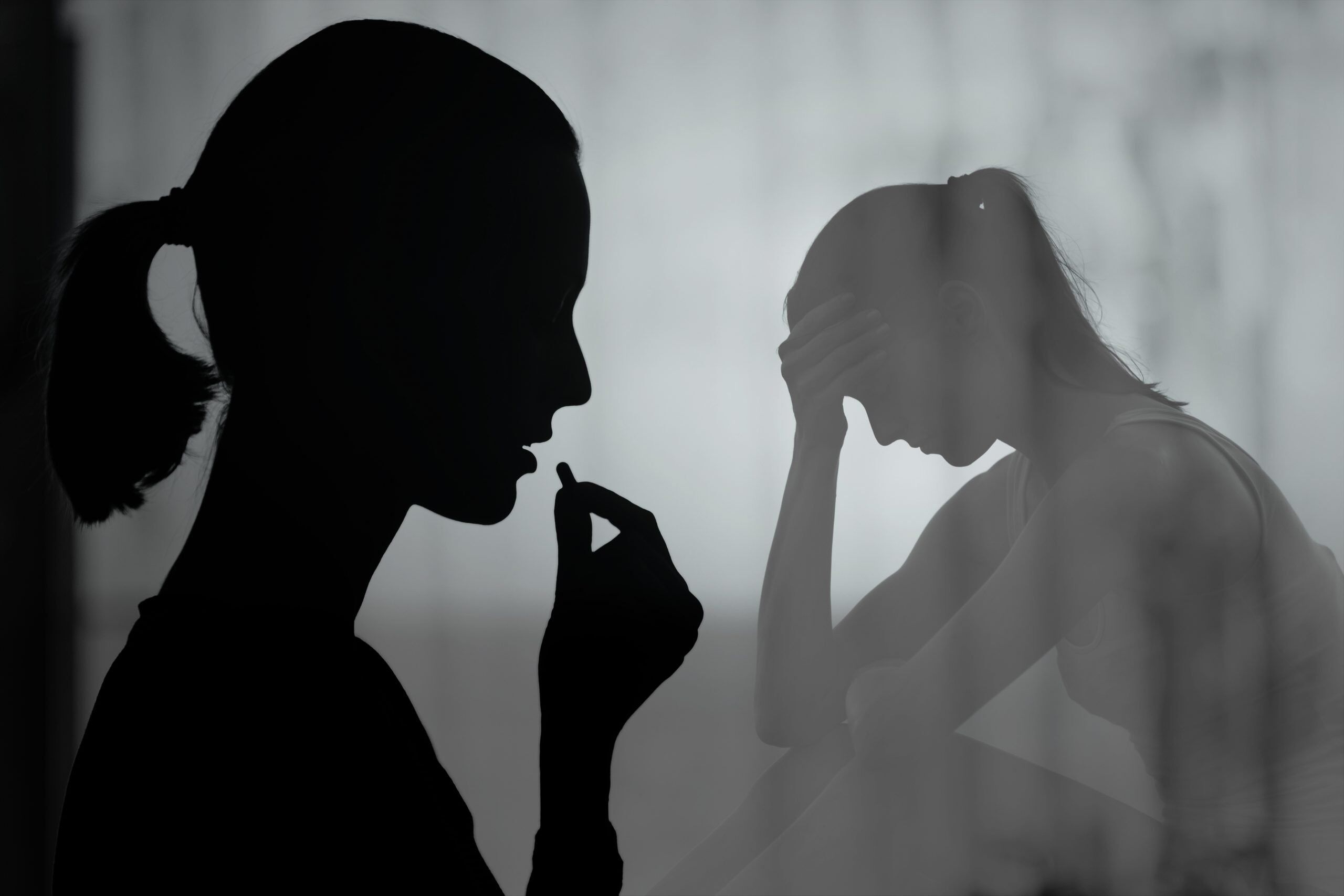 A person sitting alone with their head down, symbolizing the struggle of drug addiction and its recognition as a disability.