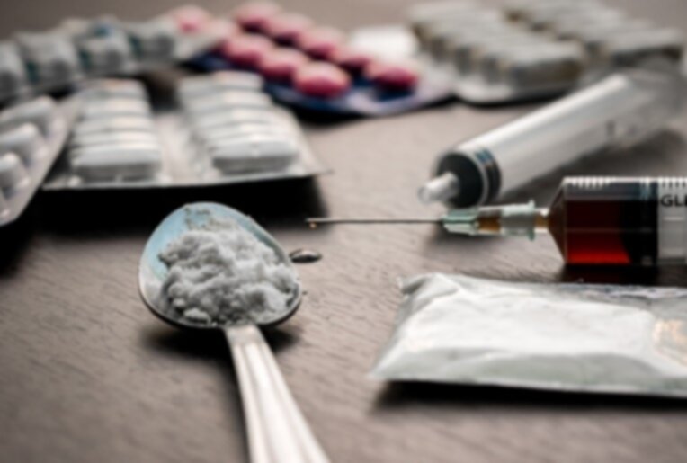 A variety of most addictive drugs, including pills, powder, and syringes, representing the most addictive substances.