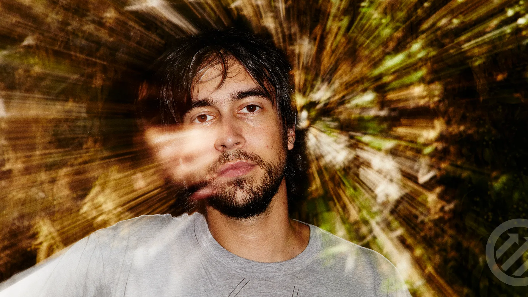Alex G performing live on stage with a guitar, known for his introspective indie music and abstract lyrics.