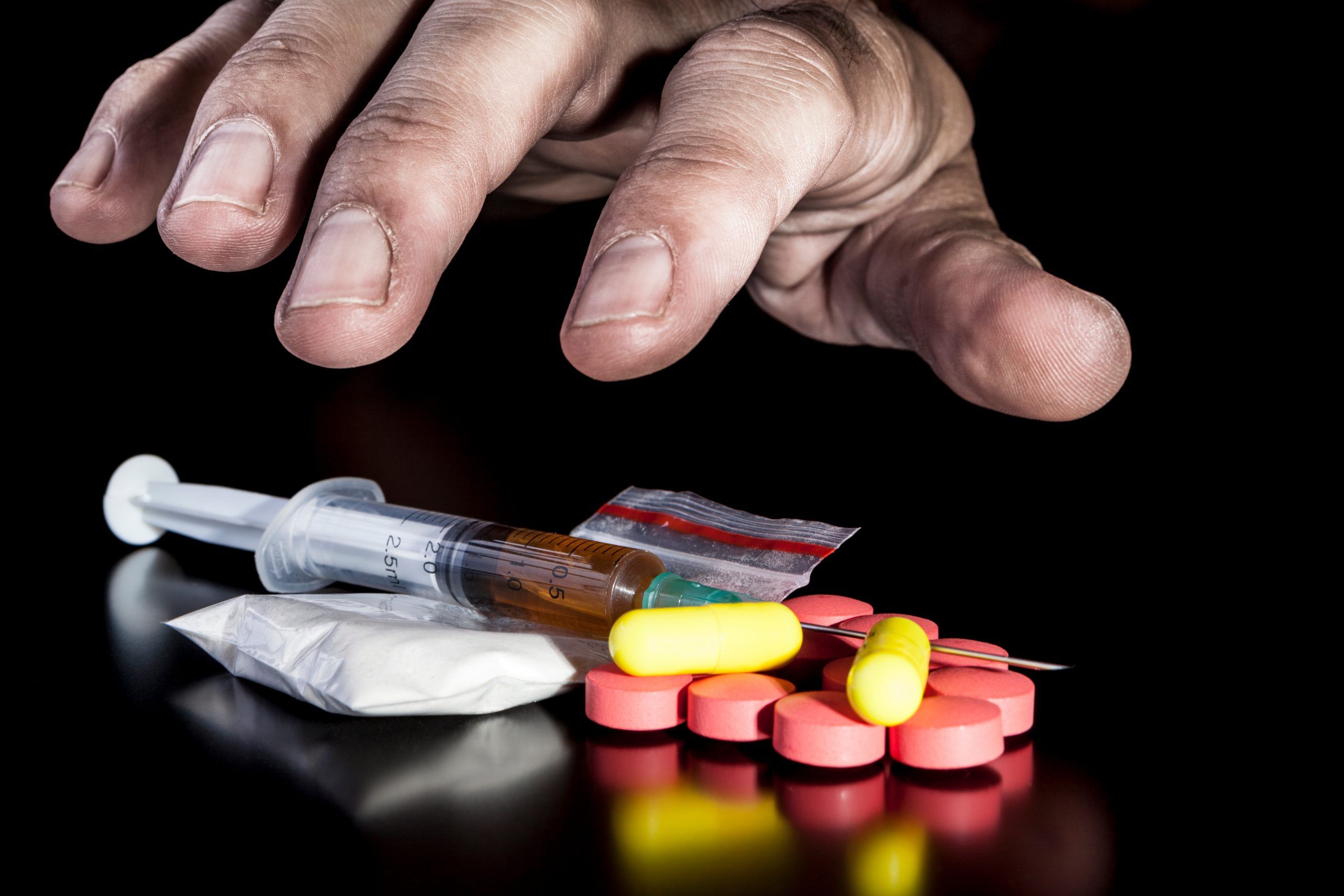 Person holding prescription pill bottle with a distressed expression, illustrating opioid dependence.